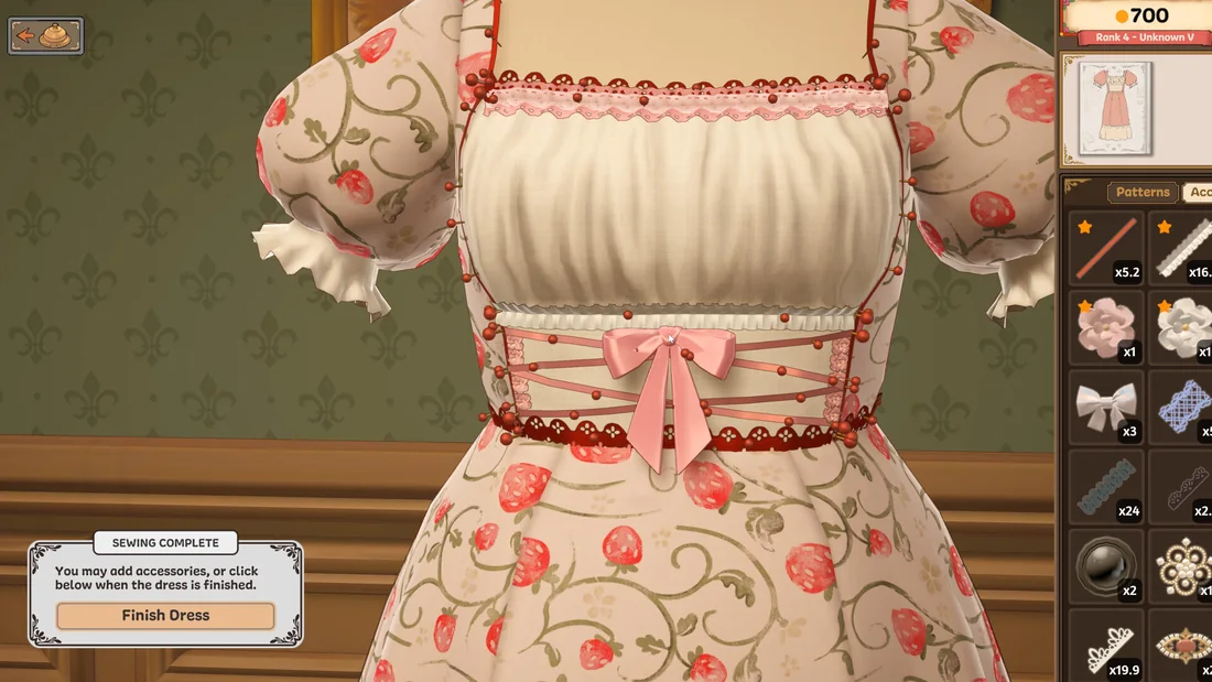 A finished strawberry-print dress on a mannequin beside a tray of accessories